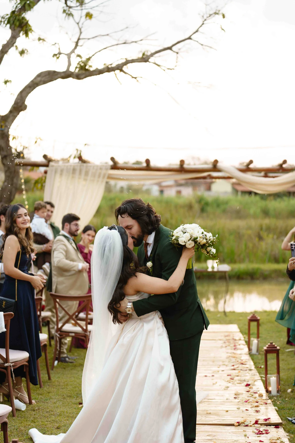 Gabriela e Raphael se beijam durante a cerimônia ao ar livre