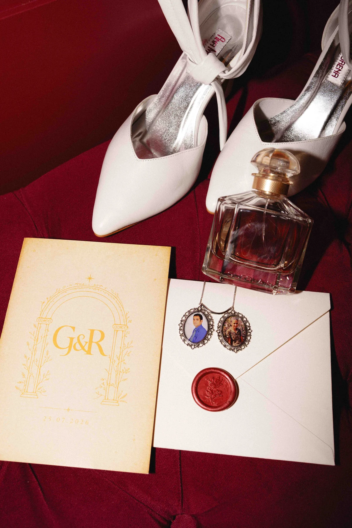 Papelaria do casal com monograma dourado, lacre vinho, sapatos e perfume